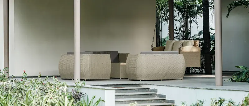 Pergola altında hasır örgü bahçe oturma grubu, yeşillik içinde